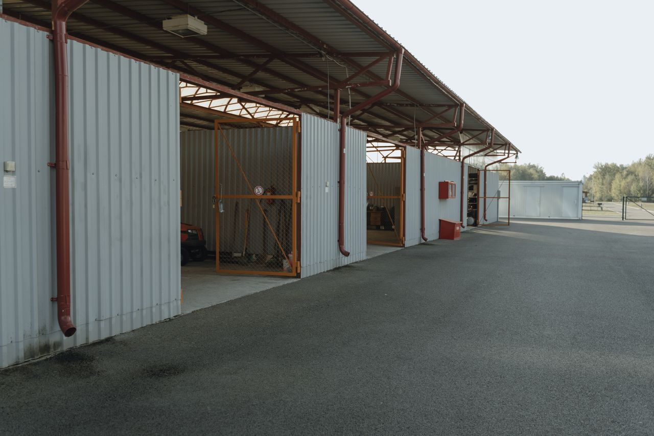 Small industrial garage with open doors and a paved outdoor area